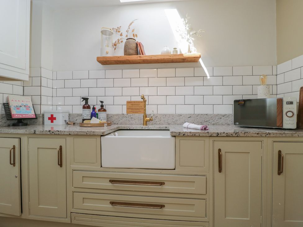 A kitchen with a sink and a microwave at Cotswold House Moreton-In-Marsh