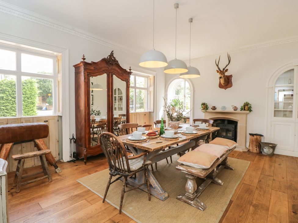 A dining room with a table set for meals at Cotswold House, Moreton-In-Marsh