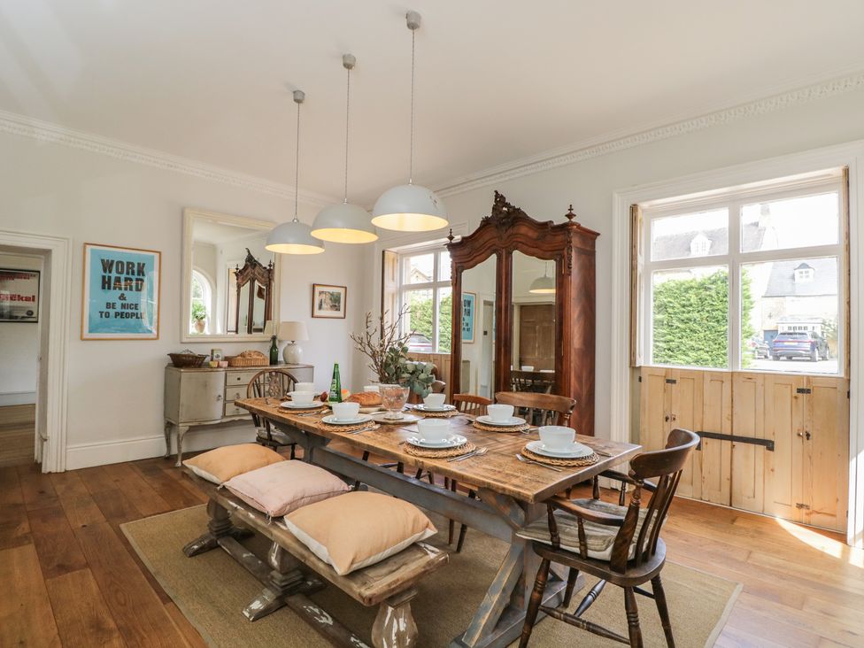 A dining room with a large table set for a meal at Cotswold House in Moreton-In-Marsh