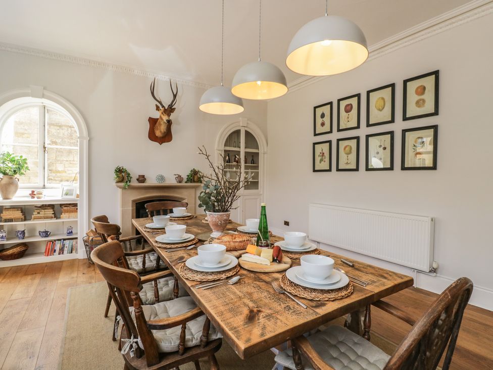 A dining room with a wooden table set for a meal at Cotswold House Moreton-In-Marsh