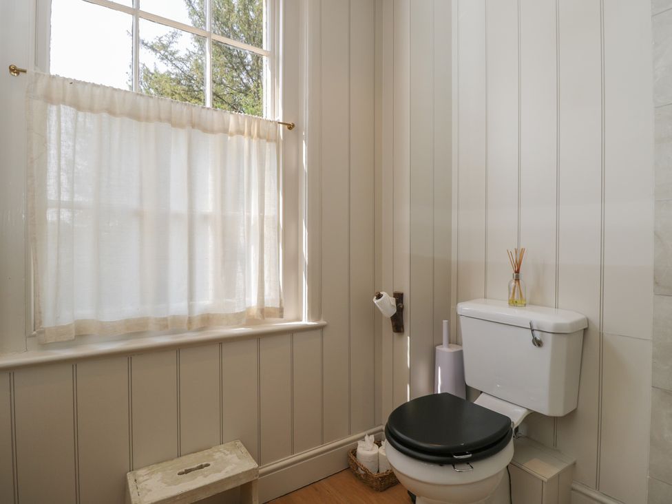 A bathroom with a toilet and curtain at Cotswold House Moreton-In-Marsh