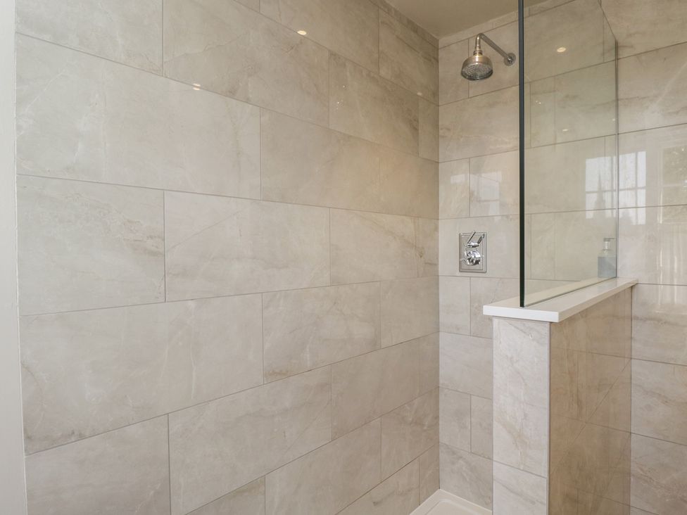 A shower with tiled walls and glass panel at Cotswold House Moreton-In-Marsh