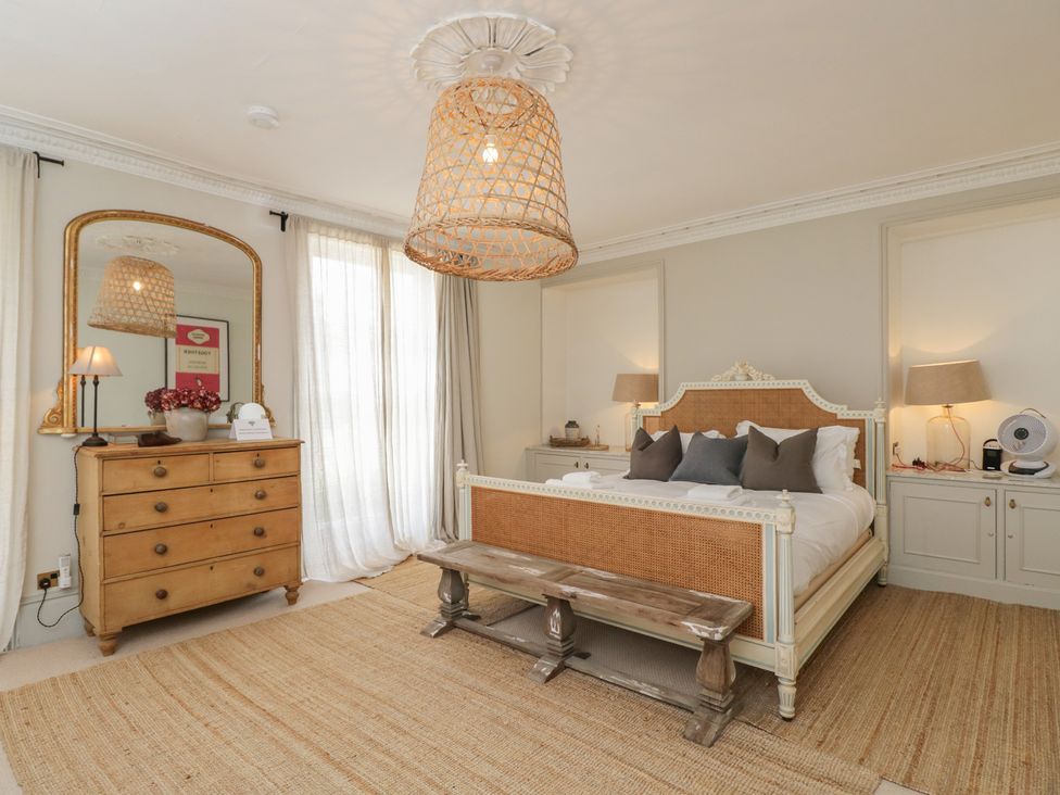 A bedroom with a bed and dressing table at Cotswold House in Moreton-In-Marsh