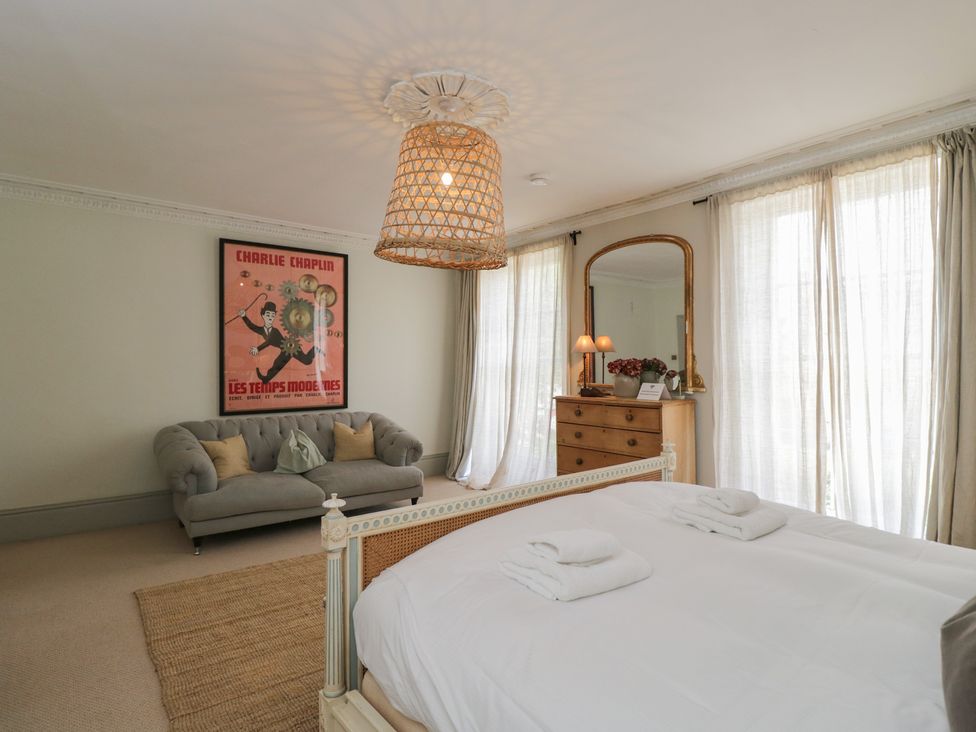A bedroom with a bed and a couch at Cotswold House in Moreton-In-Marsh