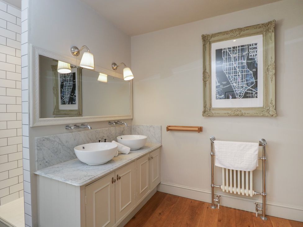 A bathroom with double sinks and mirrors at Cotswold House in Moreton-In-Marsh