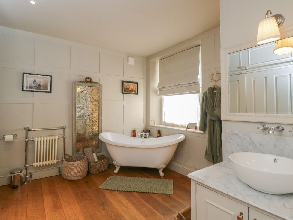 A bathroom with a bathtub and sink at Cotswold House in Moreton-In-Marsh