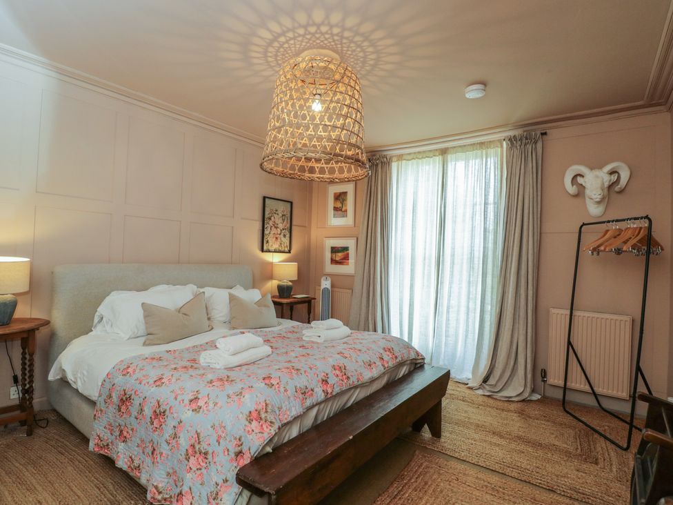 A bedroom with a bed and light fixture at Cotswold House Moreton-In-Marsh