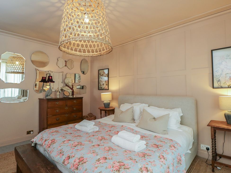 A bedroom with a bed and mirrors in Cotswold House Moreton-In-Marsh