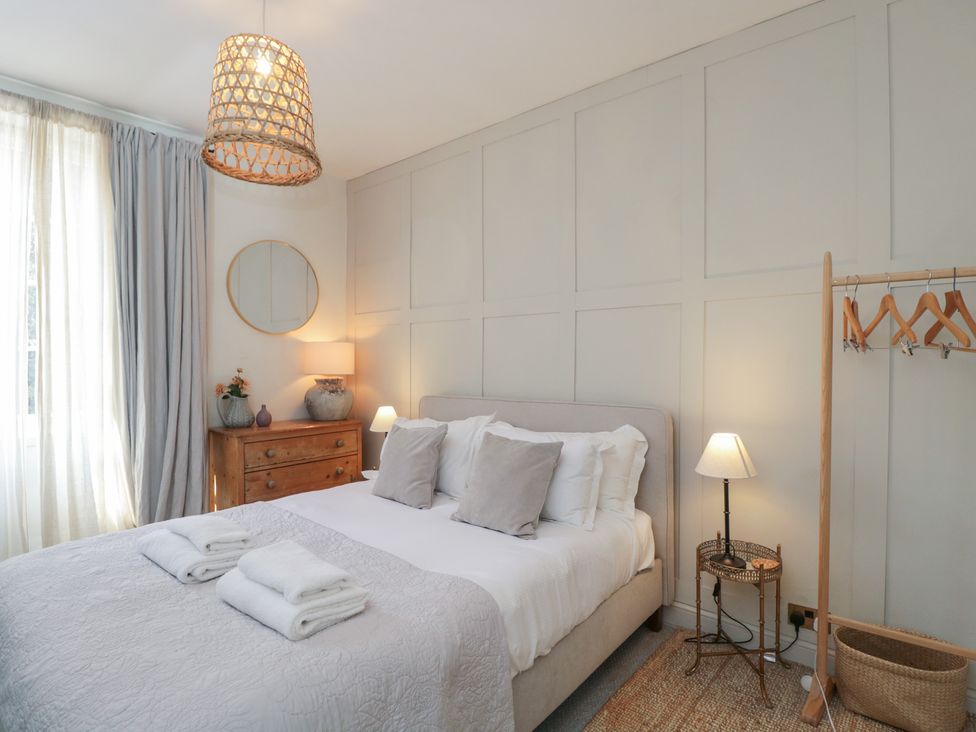 A bedroom with a bed and dresser at Cotswold House Moreton-In-Marsh