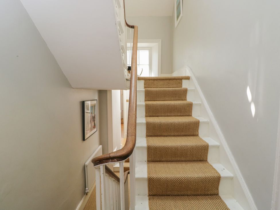 A staircase with a handrail and framed picture at Cotswold House in Moreton-In-Marsh