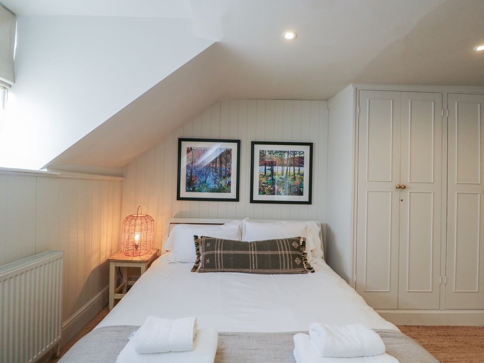 A bedroom with a bed and artwork on the wall at Cotswold House Moreton-In-Marsh