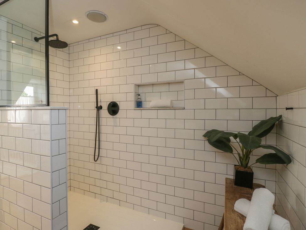 A bathroom with a shower and shelf at Cotswold House in Moreton-In-Marsh