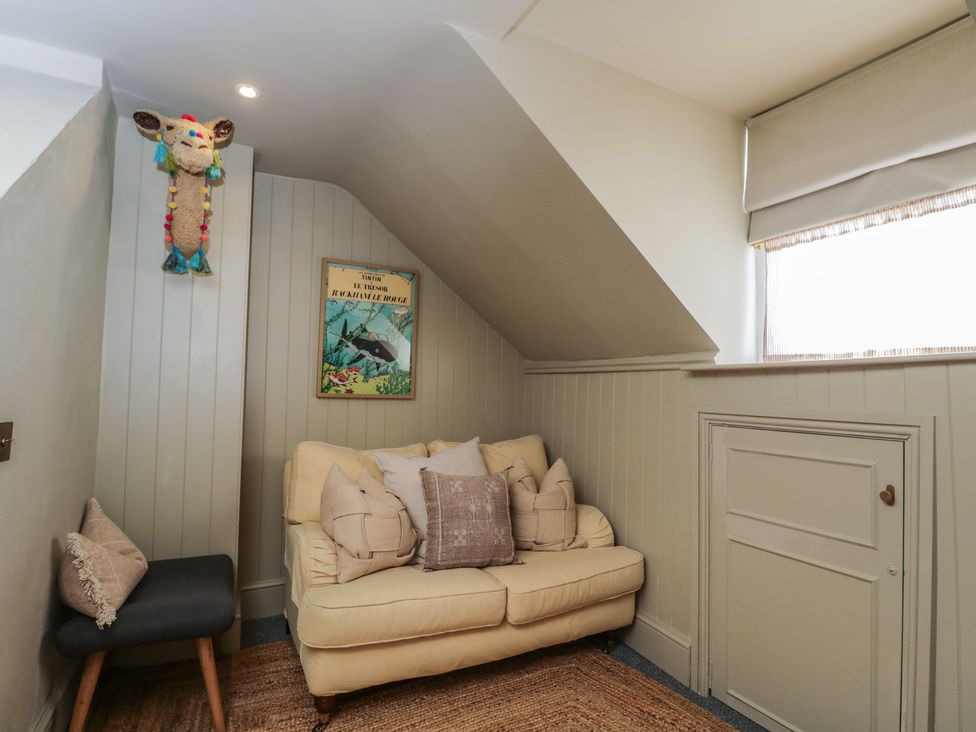 A snug with a sofa and wall art at Cotswold House in Moreton-In-Marsh