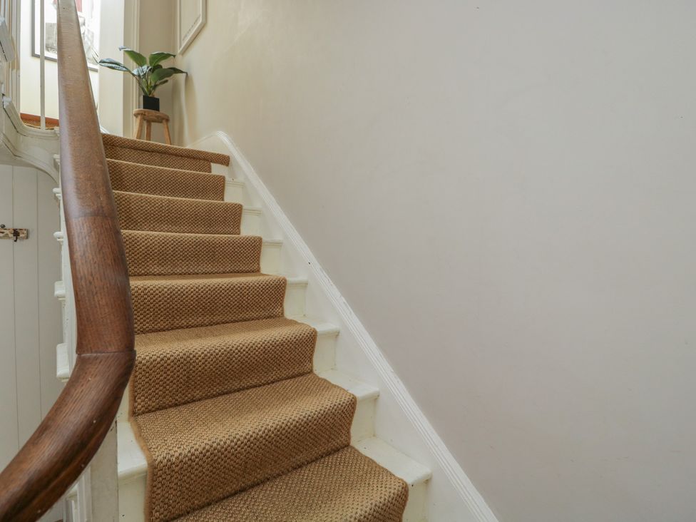 A staircase with a handrail and a plant at Cotswold House in Moreton-In-Marsh