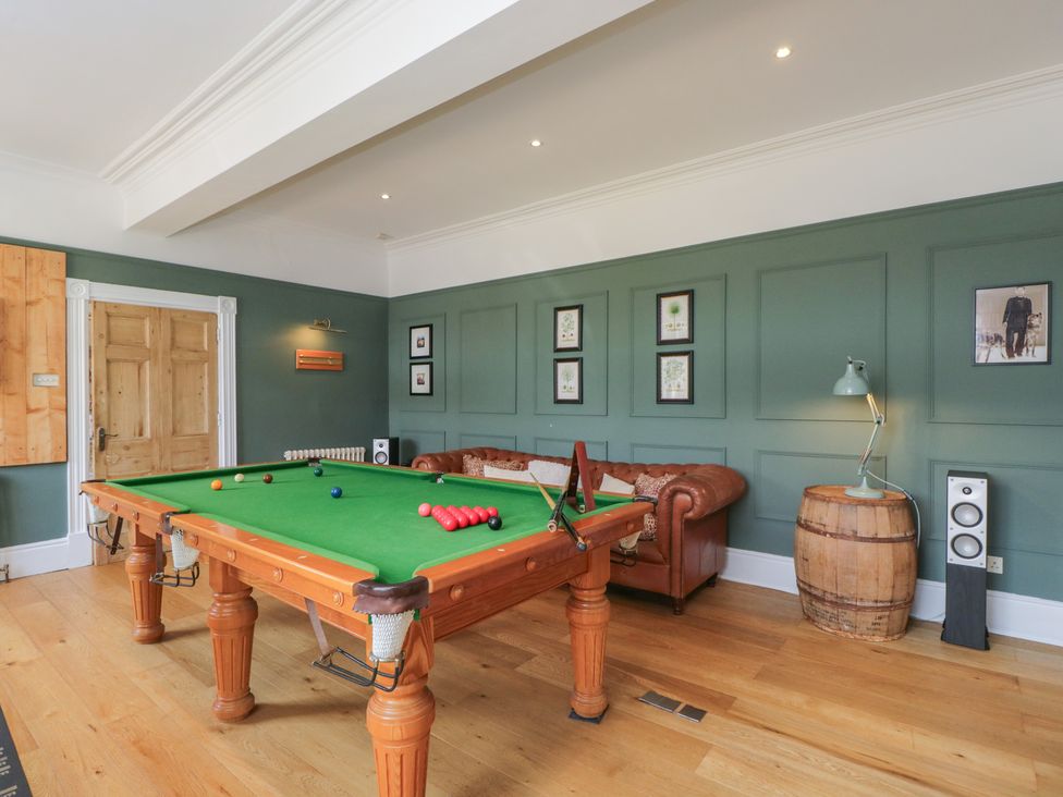 A game room with a pool table and sofa at Cotswold House in Moreton-In-Marsh