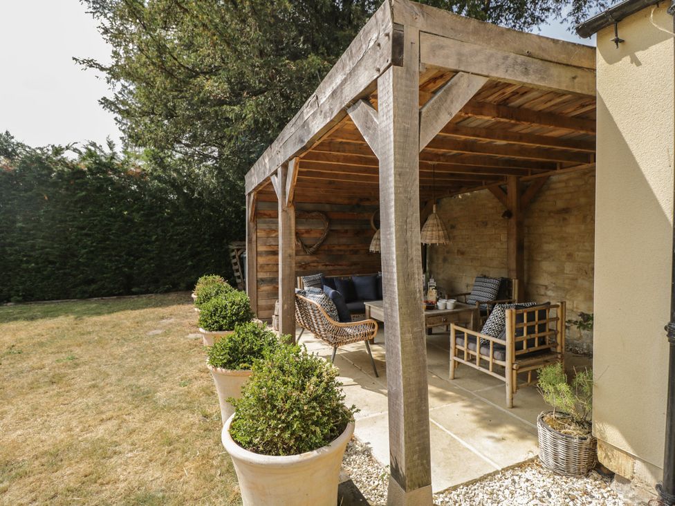 A garden with a gazebo and seating area at Cotswold House in Moreton-In-Marsh