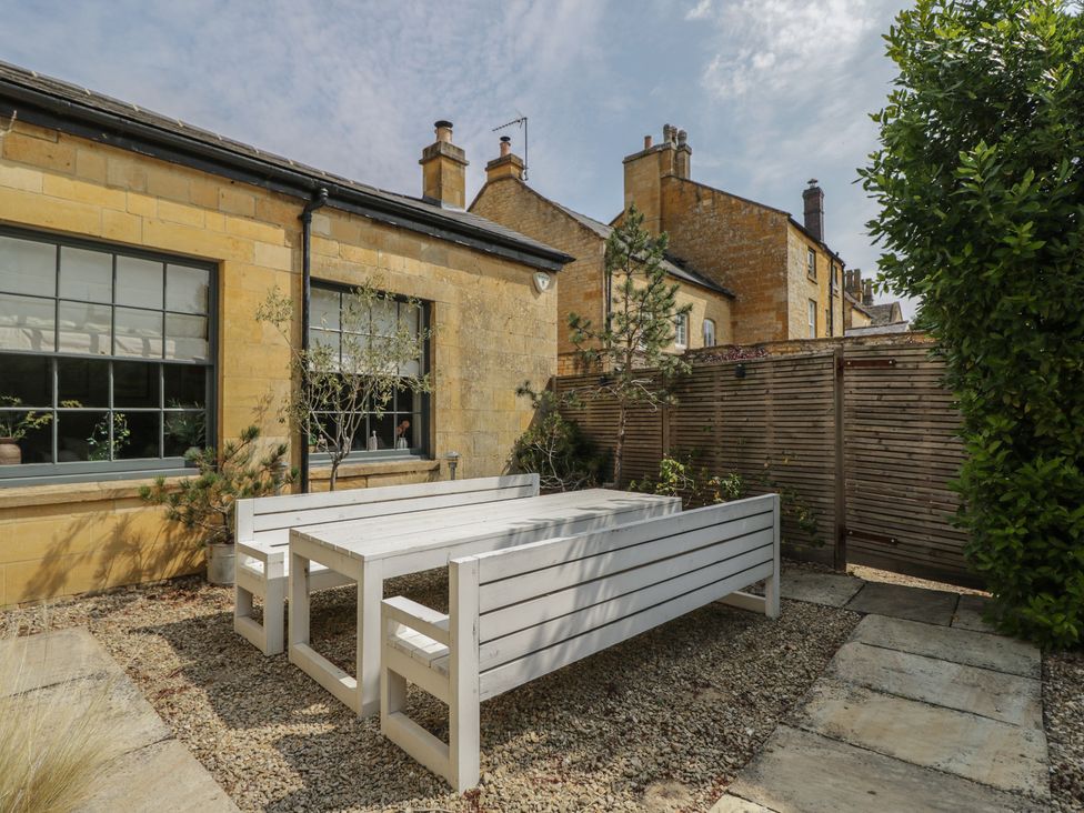 A garden with a table and benches at Cotswold House in Moreton-In-Marsh