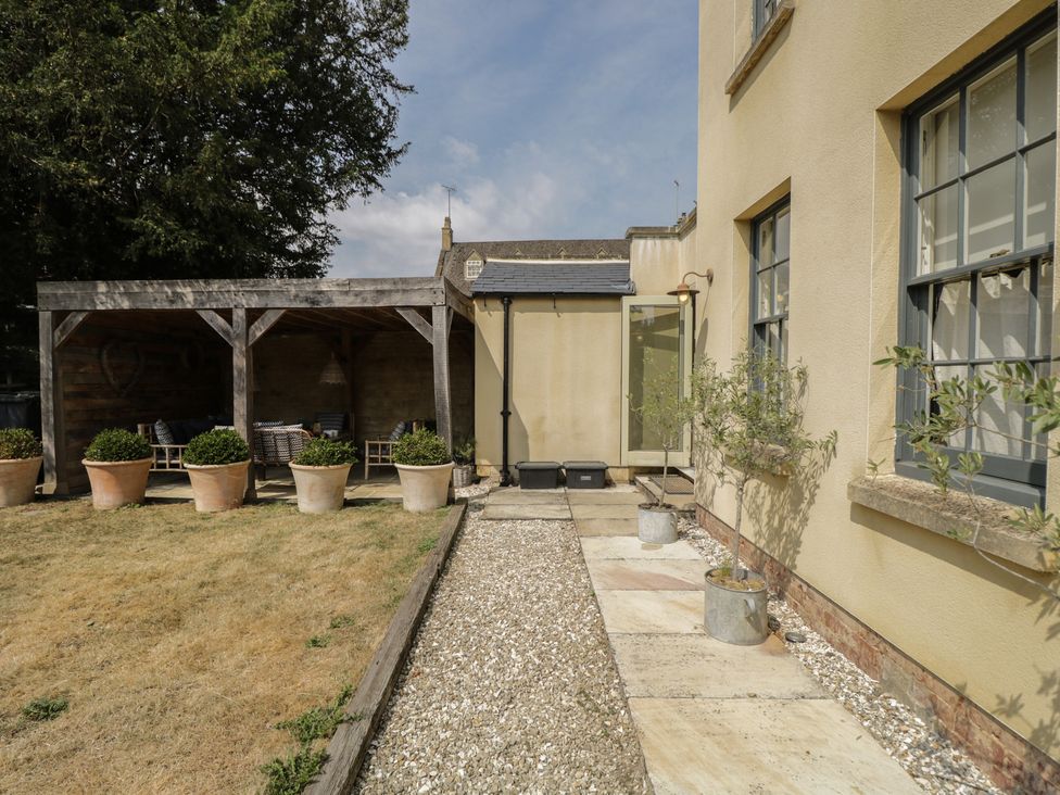 An outdoor seating area with potted plants and a gravel pathway at Cotswold House Moreton-In-Marsh