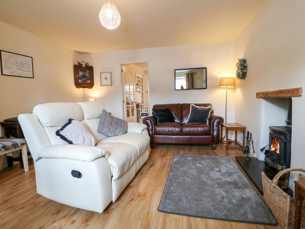 A living room with a sofa and fireplace at Rose Cottage in Hartington