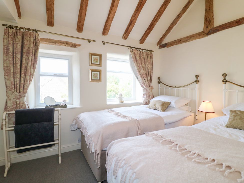 A bedroom with two beds and windows at Rose Cottage in Hartington