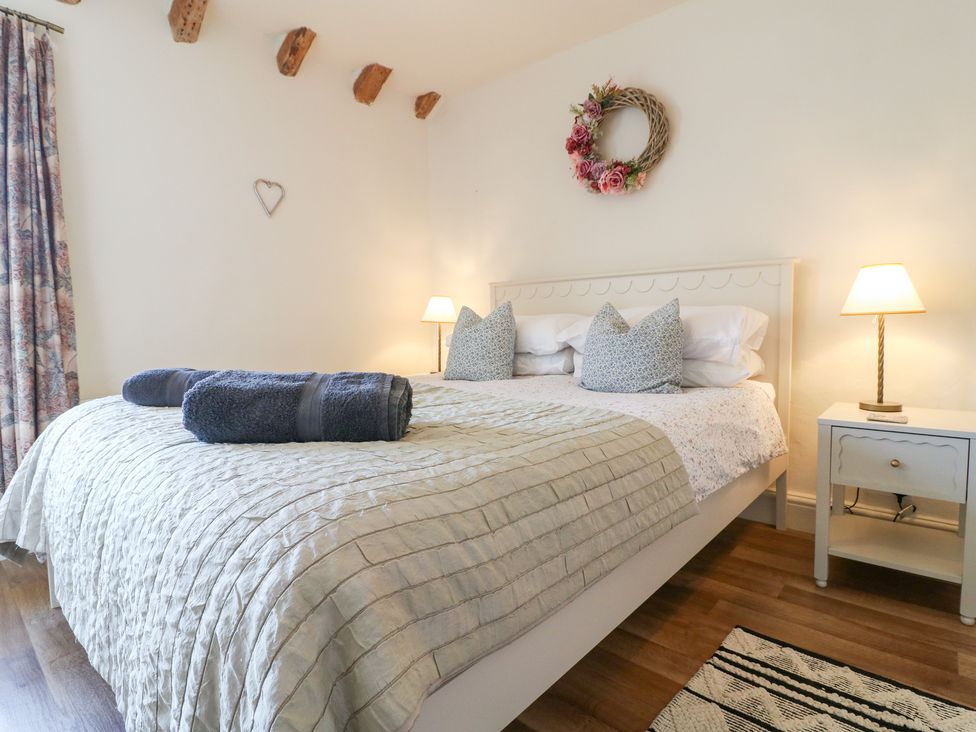 A bedroom with a bed and bedside table at Rose Cottage in Hartington