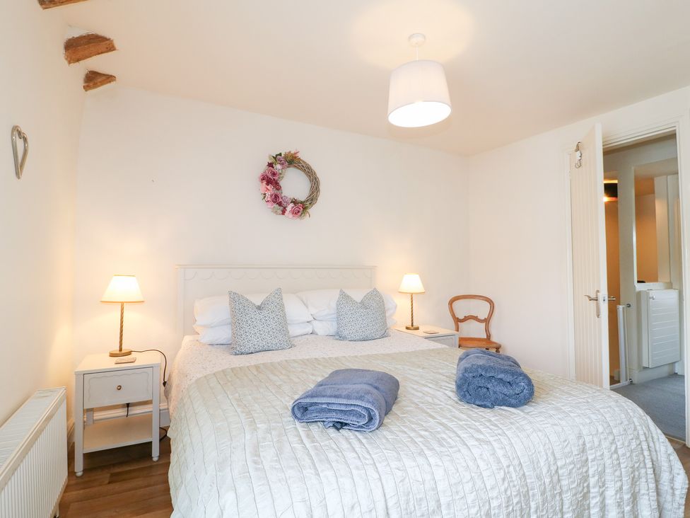 A bedroom with a bed and nightstand at Rose Cottage in Hartington