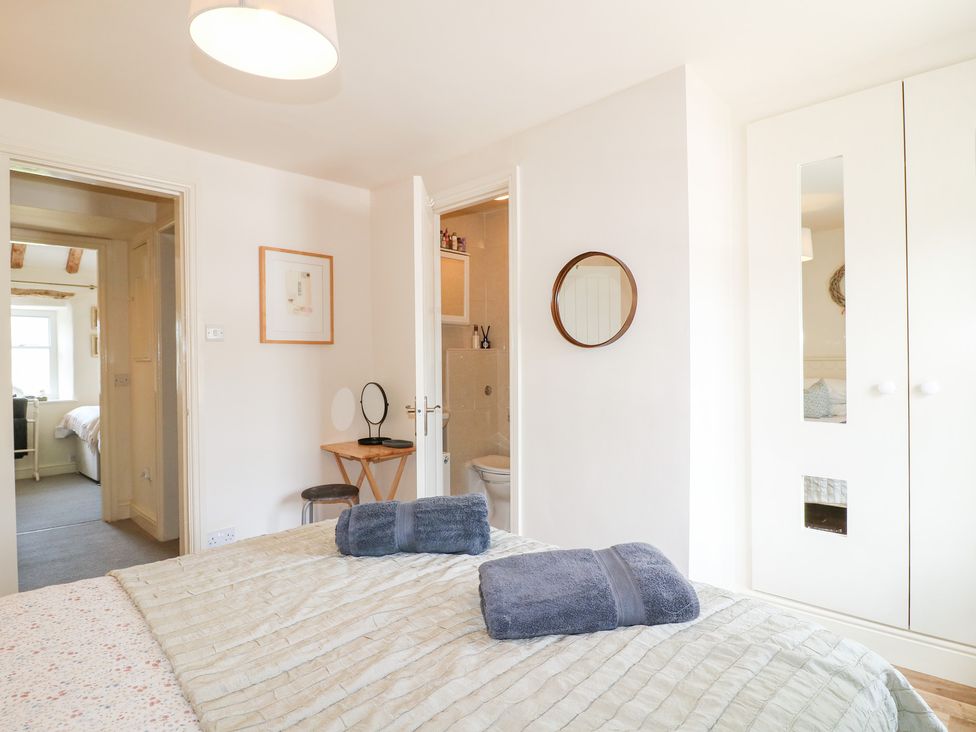 A bedroom with a bed and towels at Rose Cottage in Hartington