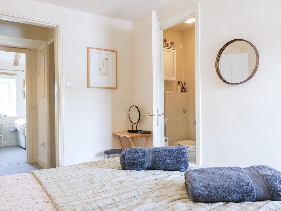 A bedroom with a bed and towels on top at Rose Cottage in Hartington