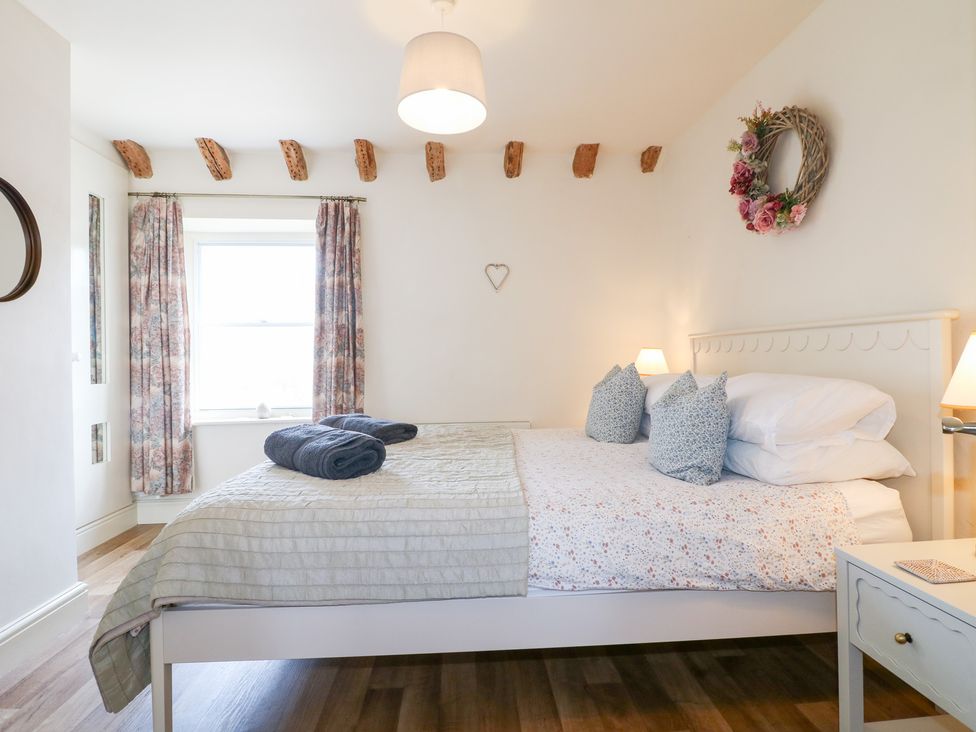 A bedroom with a bed and curtains at Rose Cottage Hartington