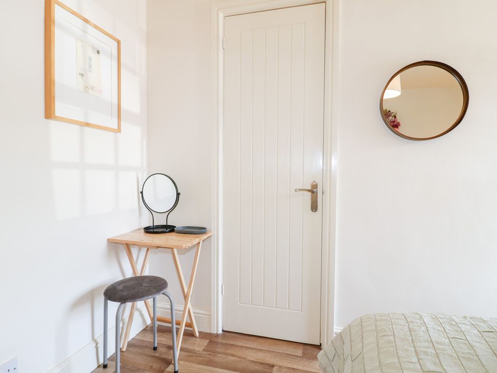 A bedroom with a mirror and table at Rose Cottage in Hartington