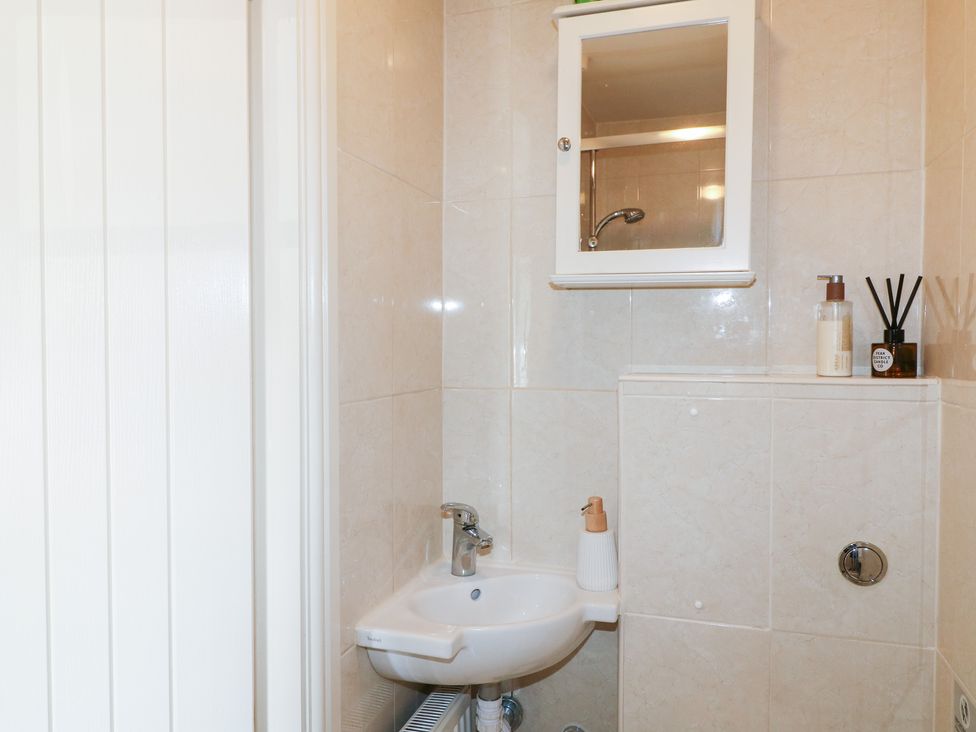 A bathroom with a sink and mirror at Rose Cottage Hartington