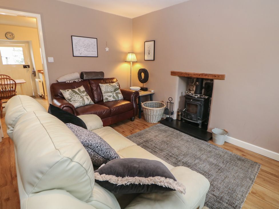 A living room with a sofa and a fireplace at Rose Cottage in Hartington