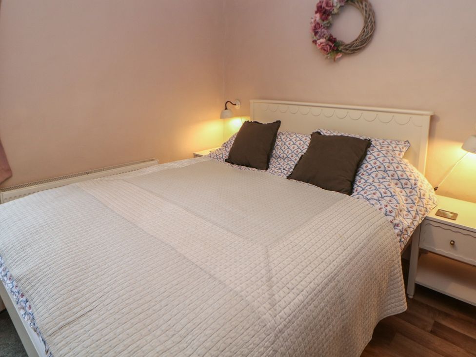 A bedroom with a bed and bedside lamps at Rose Cottage in Hartington