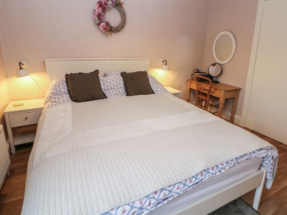 A bedroom with a bed and a desk at Rose Cottage in Hartington