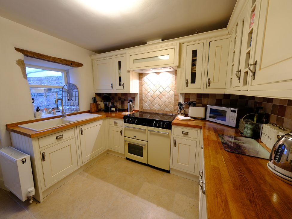 A kitchen with cabinets and appliances at Rose Cottage in Hartington