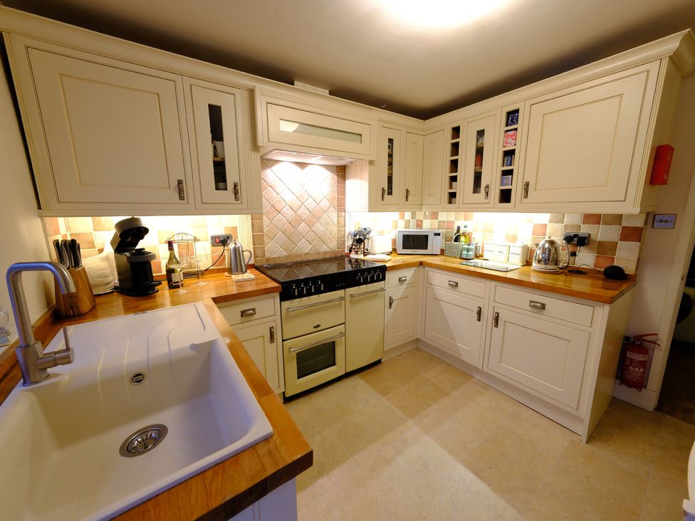 A kitchen with cabinets and appliances at Rose Cottage in Hartington