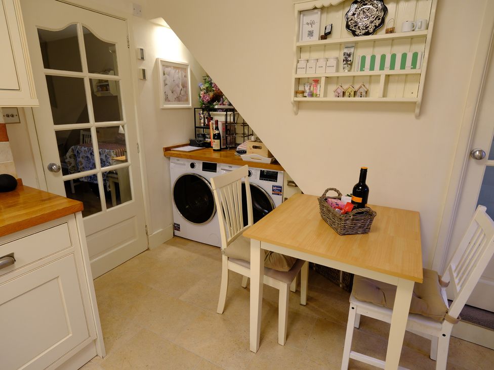 A kitchen with a table and washing machine at Rose Cottage Hartington