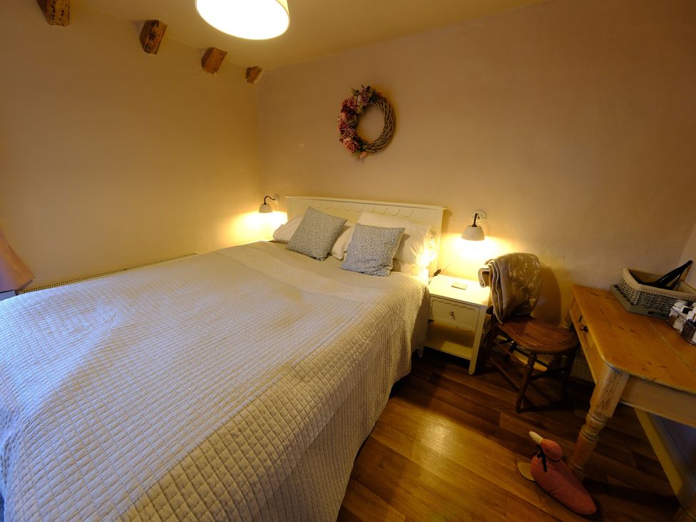 A bedroom with a bed and nightstand at Rose Cottage in Hartington