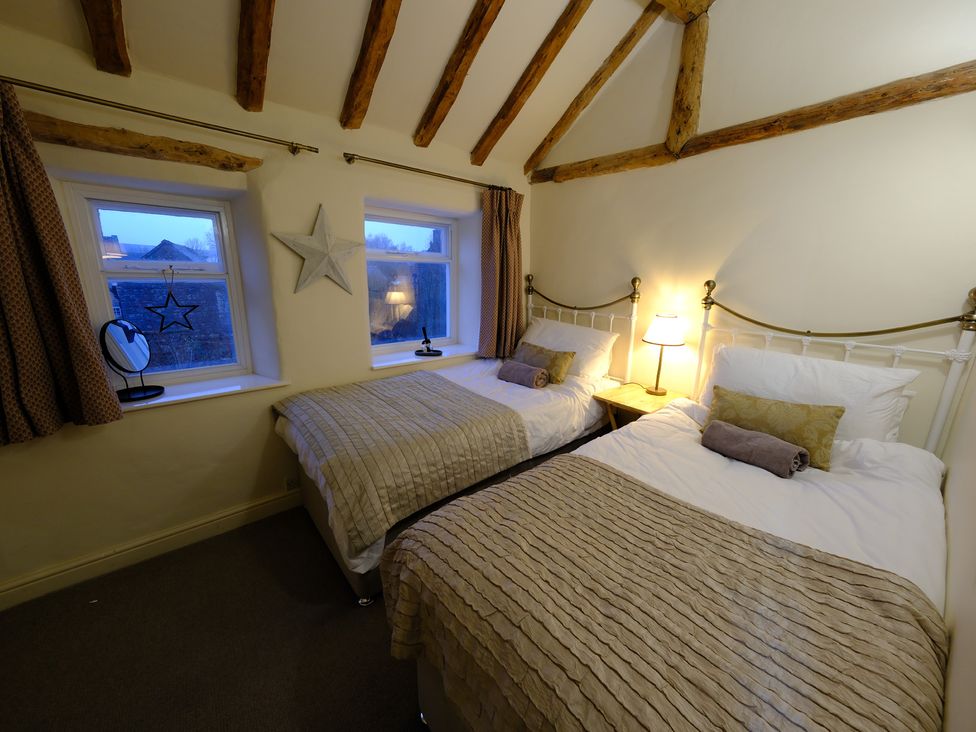 A bedroom with two beds and windows at Rose Cottage Hartington