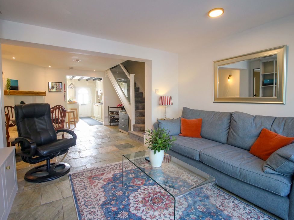 A living room with a sofa, armchair, and coffee table at Riverside Cottage in Shrewsbury
