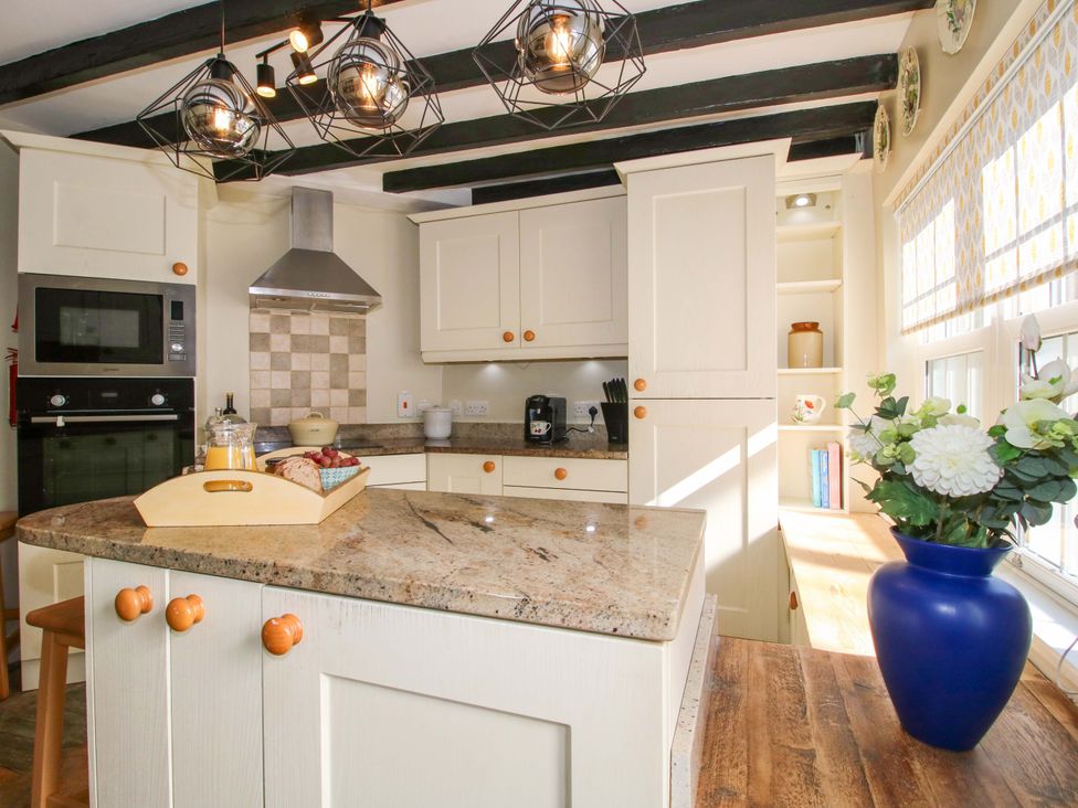 A kitchen with an island and appliances at Riverside Cottage in Shrewsbury