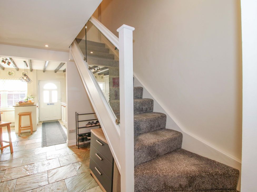 A hallway with stairs and a door at Riverside Cottage in Shrewsbury