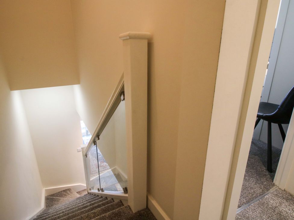 A staircase with a handrail leading to an upper level at Riverside Cottage in Shrewsbury