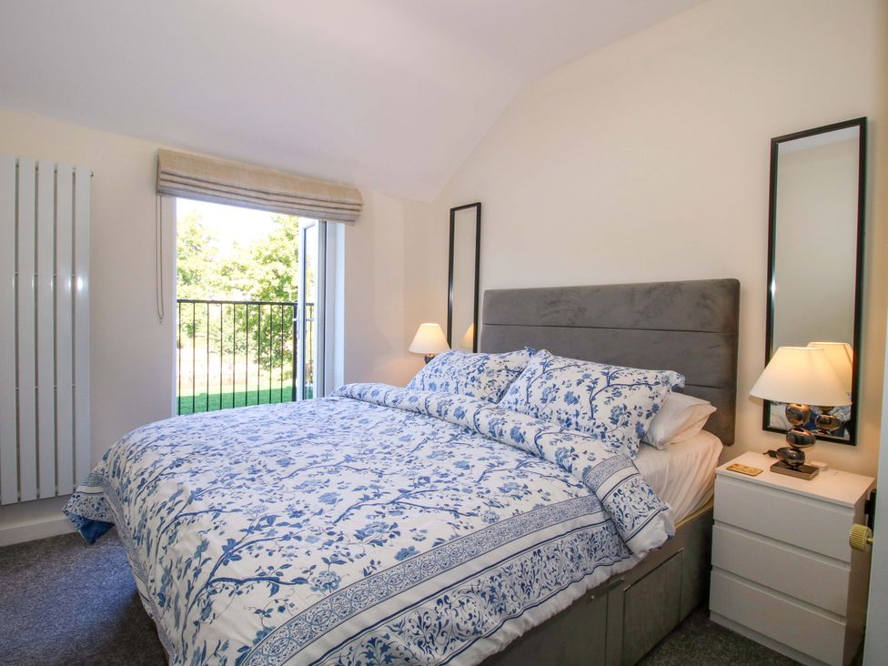 A bedroom with a bed and bedside table at Riverside Cottage in Shrewsbury