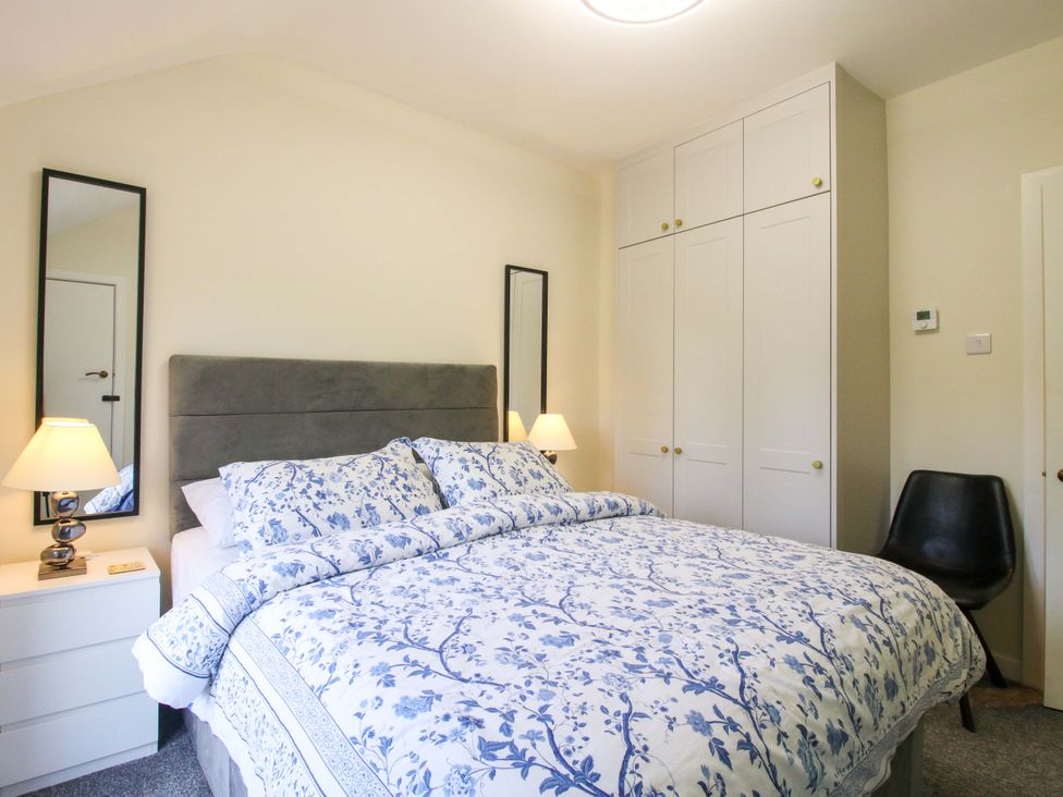 A bedroom with a bed and wardrobe at Riverside Cottage in Shrewsbury