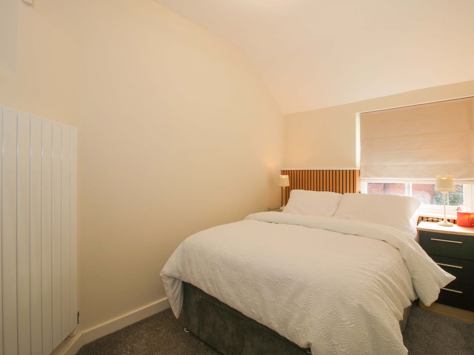A bedroom with a bed and bedside table at Riverside Cottage in Shrewsbury