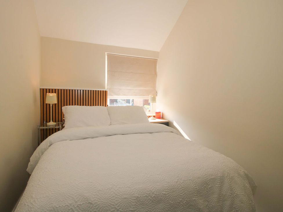 A bedroom with a bed and lamp at Riverside Cottage in Shrewsbury