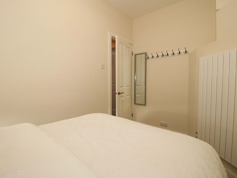 A bedroom with a bed and hooks on the wall at Riverside Cottage in Shrewsbury