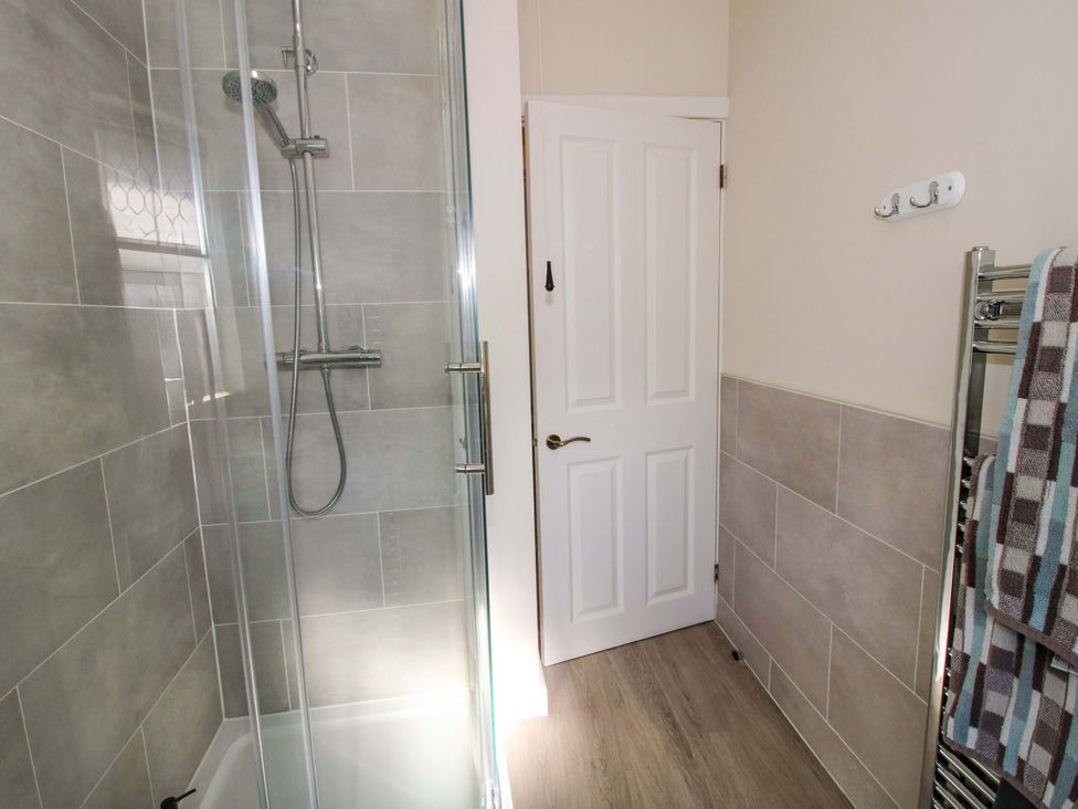 A bathroom with a shower enclosure and towels at Riverside Cottage in Shrewsbury