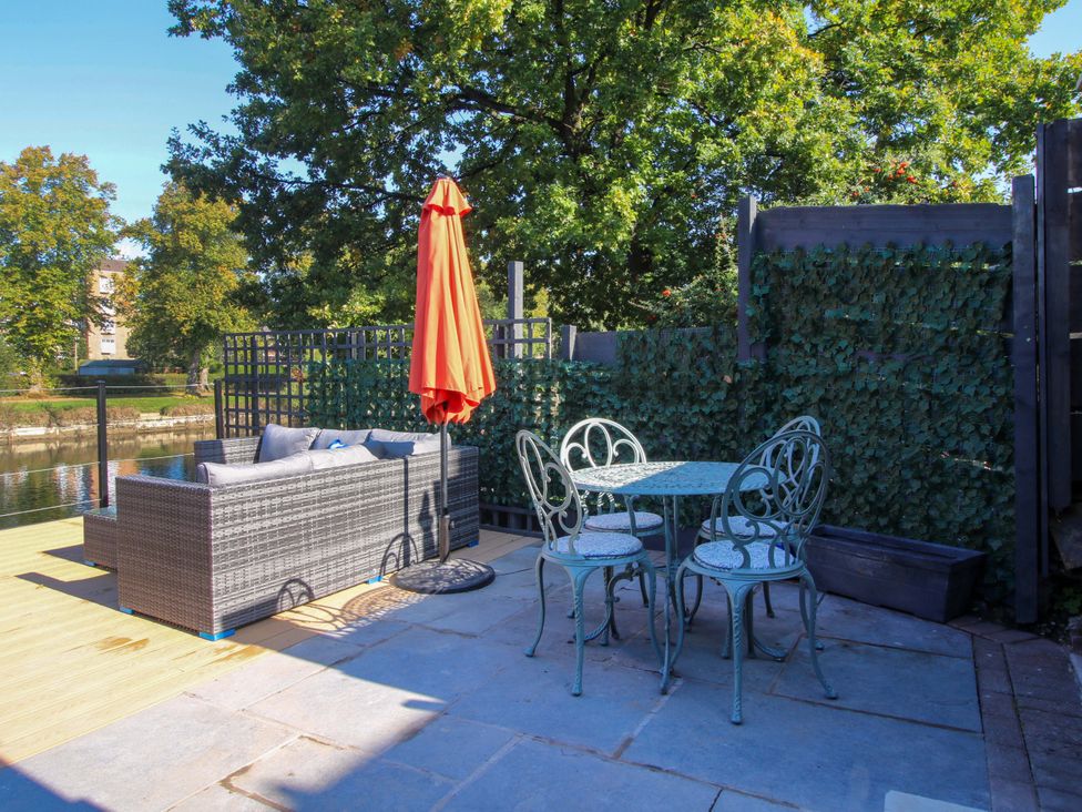 An outdoor terrace with a sofa and table at Riverside Cottage in Shrewsbury